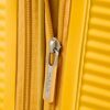 Nahaufnahme des Reißverschlusses eines gelben expandierbaren Koffers von American Tourister, der stilvoll und funktional ist.