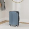 Dunkelgrüner Zwillingsrollen Hartschalen Reisekoffer 66cm auf hellen Teppichboden, modernes Design mit strukturierten Oberflächen und vier Rollen, ideal für Reisen