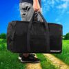 Faltbare, wasserabweisende Reisetasche mit Handschlaufe in Schwarz, ideal für Camping und Reisen, präsentiert von einer Person in sportlicher Kleidung vor einer grünen Landschaft.