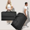 REDOLZ XXL Jumbo Trolley-Reisetasche mit Rollen in Schwarz, ideal für Reisen, präsentiert von einem Mann und einer Frau in lässiger Kleidung. Die Tasche zeigt ein elegantes Design und eine große Kapazität von 150 bis 185 Litern.