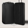 Schwarze große Jumbo Trolley-Reisetasche mit Rollen, geöffnet, zeigt zwei Fächer für saubere und schmutzige Wäsche. Praktisches Design für stilvolles und organisiertes Reisen.