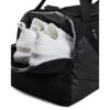Under Armour Unisex UA Undeniable 5.0 Duffle SM Backpack in Schwarz mit weißen Sportschuhen, zeigt die praktische Nutzung der Reisetasche für Sport und Freizeit.
