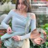 Junge Frau mit modischer hellgrüner Crossbody Tasche LUCA, die ein elegantes Outfit trägt und in einer grünen Umgebung steht, was die Funktionalität und den Stil der Tasche unterstreicht.