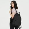Schwarzer WANDF Rucksack mit Kordelzug, ideal als Sporttasche mit Schuhfach, präsentiert von einer jungen Frau in modernem Outfit.