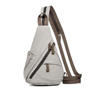 Eine graue Canvas Sling Bag mit zwei verstellbaren Schultergurten. Der Rucksack hat eine gekrümmte Vorderpocket und zwei Seitenpockets. Die Gurte sind schwarz und haben silberne Schnallen. Der Rucksack liegt auf einem weißen Surface. Der Rucksack scheint aus Canvas-Material gefertigt zu sein.